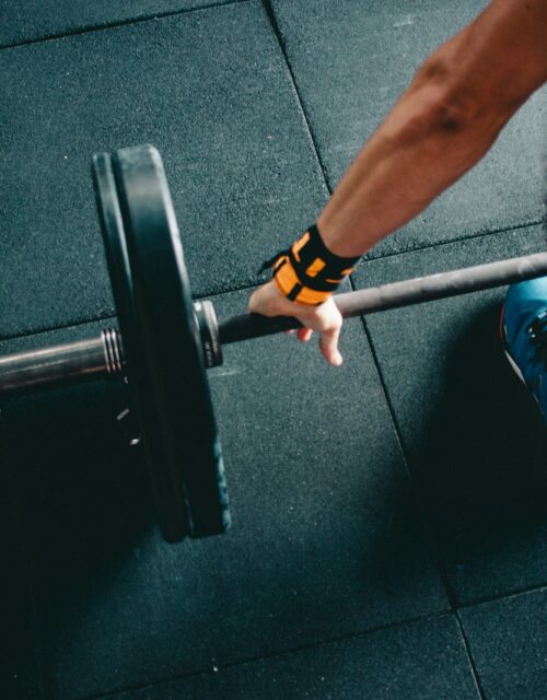 man holding black barbell